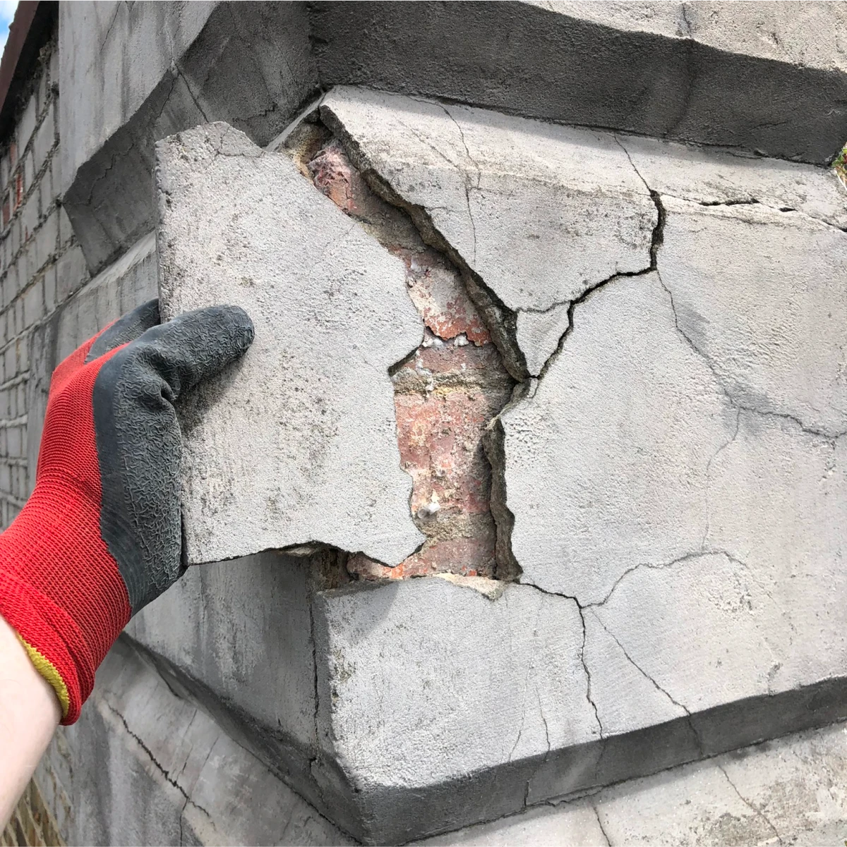 Concrete render - Shattering and radiating cracks leading to lose and missing render.