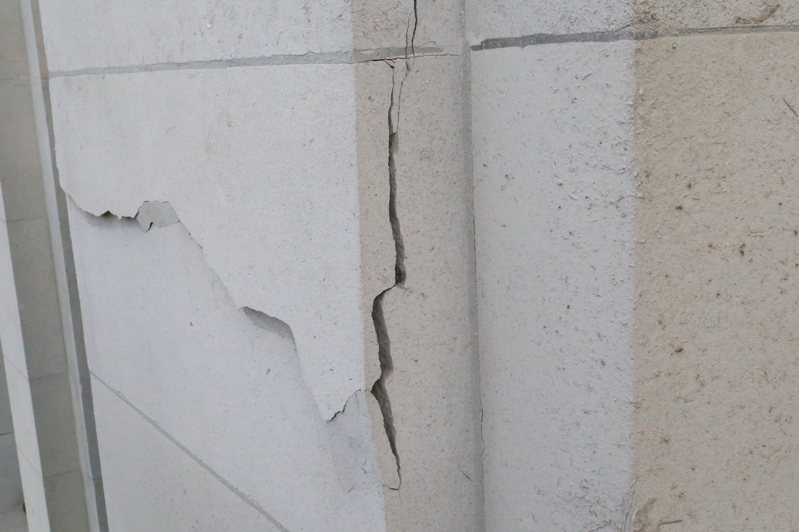 An image of a significant crack which has covered most of the front of a large limestone masonry block.