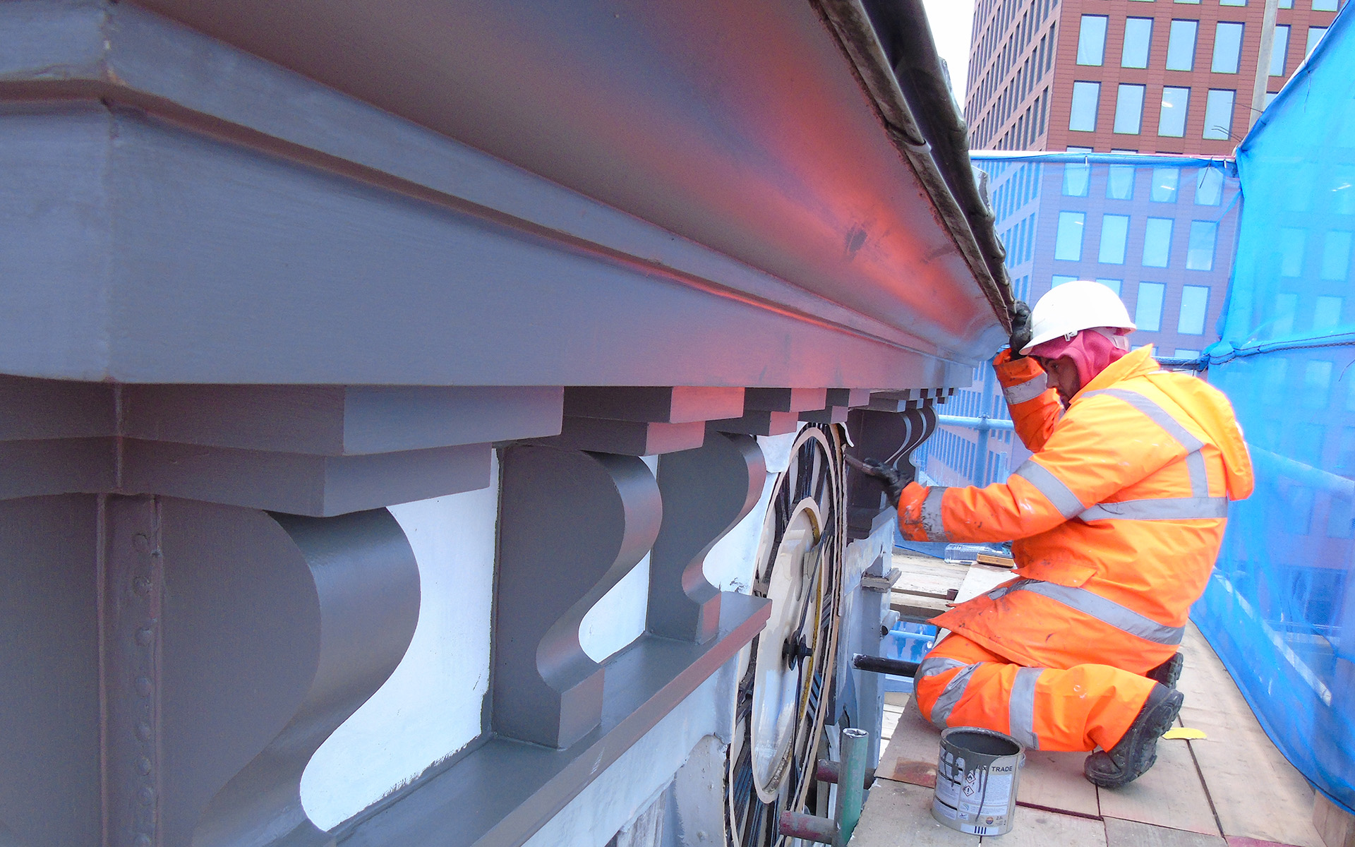 Thomann-Hanry® staff member painting the timber elements of a clock tower